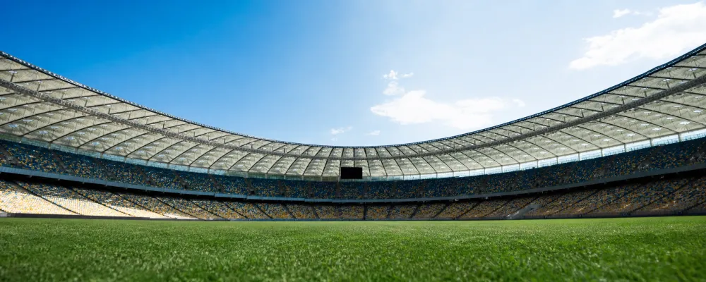 Estadio de fútbol al aire libre bajo el sol, relacionado con exposición solar y salud ocular, pterigión
