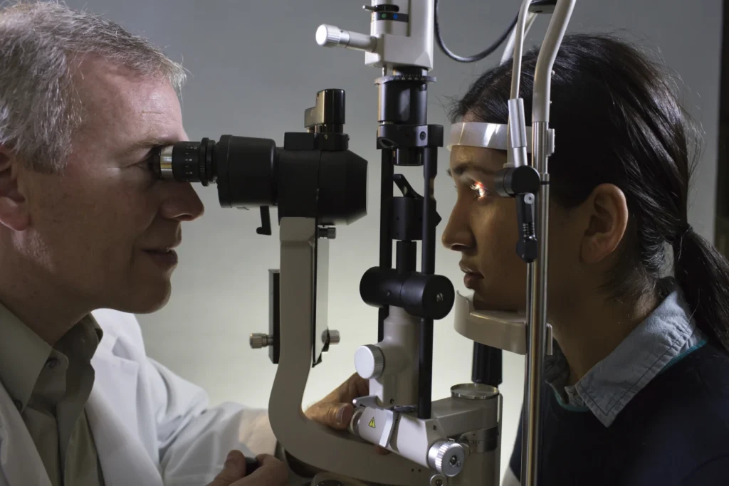 Oftalmólogo realizando un examen ocular con lámpara de hendidura durante una consulta de evaluación de la salud visual.